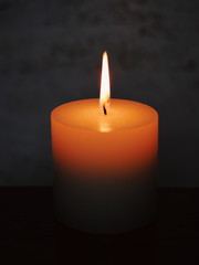 White burning candle on a dark background. Earth hour.