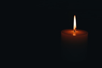Obraz na płótnie Canvas White burning candle on a dark background. Earth hour.