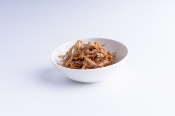 Fried anchovies on white background with selective focus and crop fragment