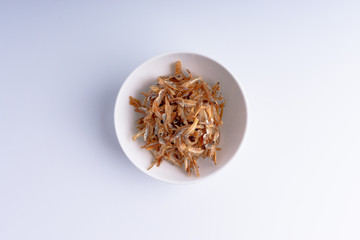 Fried anchovies on white background with selective focus and crop fragment
