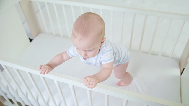 Cute baby playing in her crib at home. Close-up shot