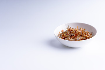 Fried anchovies on white background with selective focus and crop fragment