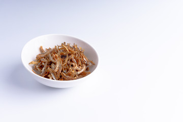 Fried anchovies on white background with selective focus and crop fragment