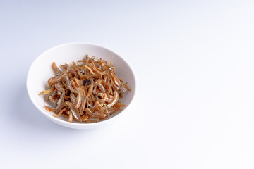 Fried anchovies on white background with selective focus and crop fragment
