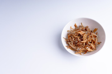 Fried anchovies on white background with selective focus and crop fragment