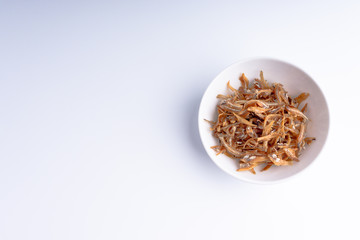 Fried anchovies on white background with selective focus and crop fragment
