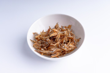 Fried anchovies on white background with selective focus and crop fragment
