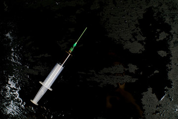 A syringe with a drug on a dark background.