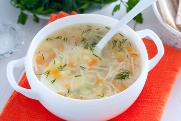 Chicken vermicelli soup and potatoes in a white bowl, horizontal