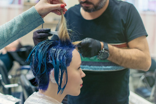 Hairdresser, stylist makes coloring of the hair of a woman in the hairdresser's salon.