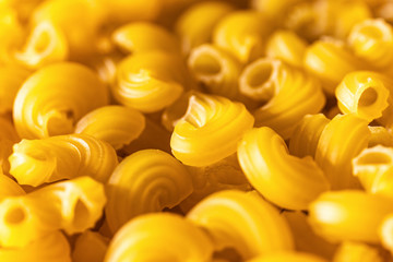Pasta penne raw close-up. Focus with shallow depth of field. Italian design background, texture.