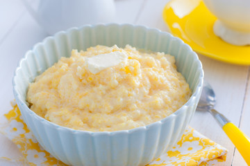 Milk corn porridge in a blue bowl, horizontal