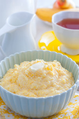 Milk corn porridge in a blue bowl for breakfast, selective focus