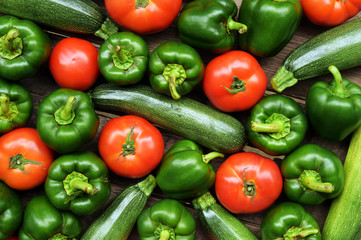 Cucumbers, tomatoes and sweet pepper on wooden table for background