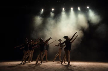 Abwaschbare Fototapete Ballettunterricht auf der Bühne des Theaters mit Licht und Rauch. Kinder üben auf der Bühne klassische Übungen aus. © nagaets