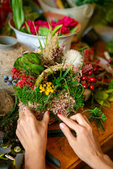 Female hands making beautiful bouquet of flowers on background