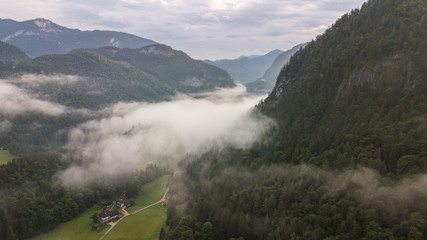 Obraz premium Aerial view of the morning foggy landscape in the alpine mountains