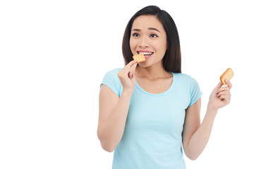 Portrait of young beautiful woman eating crackers for snack