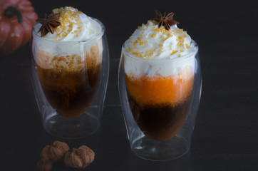 Hot pumpkin spice drink with whipped cream decorated with anise star and gold sugar. Perfect beverage for crisp autumn days and ultimate coziness