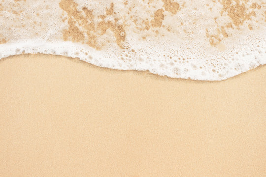 Soft ocean wave on sandy beach background