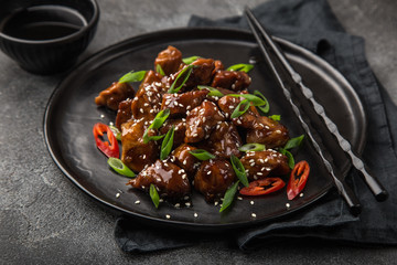 sweet sticky pork served with chives and  sesame seeds