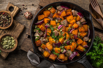 roasted pumpkin with meat on cast iron pan,  rustic backgroun