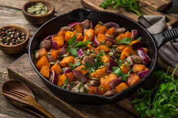 roasted pumpkin with meat on cast iron pan,  rustic backgroun