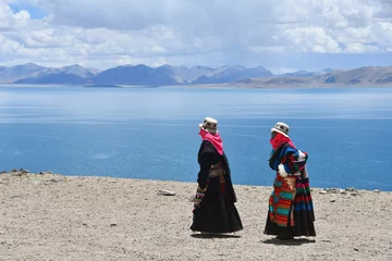 Zelfklevend Fotobehang  Two women in traditional Tibetan clothes make parikrama around the lake Tere Tashi Namtso in Tibet, China © irinabal18