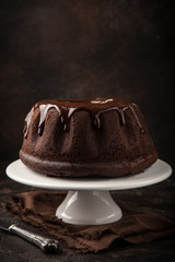 delicious chocolate bundt cake with chocolate glaze on  dark background