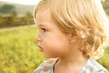 Portrait of a little girl in the countryside. Concept of beautiful children