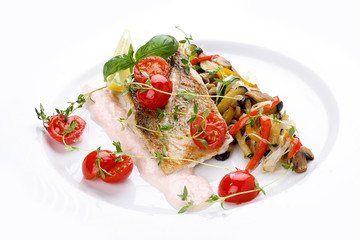 Sudak with vegetables on a white dish.