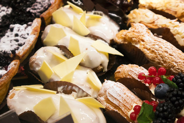 Different types of appetizing cakes lying in a showcase in café