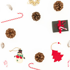 Winter frame composition. Christmas gift, toys, pine cones and candy canes on white background. Flat lay, top view.