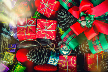 Merry Christmas holiday background concept. Closeup of red gift boxes with decorated accessories stacked on ground.