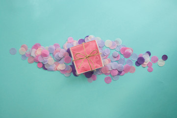 Multicolored confetti and sparkles on blue background.