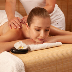Plakat Beautiful young woman having a massage treatment in spa salon - wellness