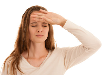 Beautiful young brunette woman holds her head as she has headache - illness