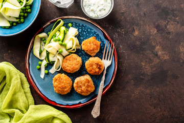 Chicken meat balls with zucchini salad and green peas, with garlic-yogurt sauce.