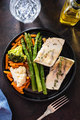 Pike perch fillet with asparagus, broccoli and carrots. Fried fish with stewed greens