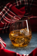 Still-life with a glass of bourbon. A glass of whiskey with ice. Concept of autumn spleen