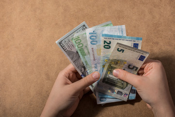 Hand holding American dollar  isolated on wooden background