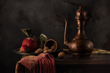 Still life with a copper jug, apples and nuts on a wooden table