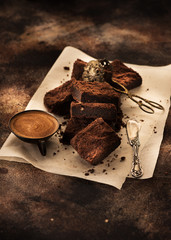 Chocolate cake browns, cup espresso coffee and cake tongs