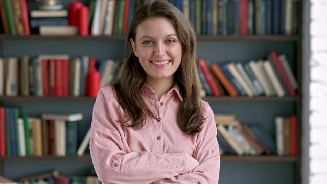 Closeup portrait of posh university student. Gorgeous young woman looking at camera smiling and laughing in working interior. Slow motion