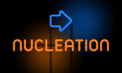 Nucleation - orange glowing text with an arrow on dark background