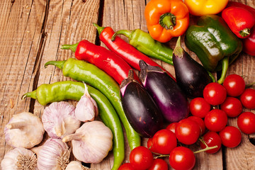 Cherry tomatoes, peppers, garlic, eggplants on a wooden table. Fresh organic vegetables..