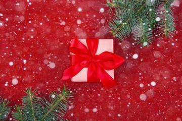 Christmas gifts with red ribbon on red background with decorations. Christmas background with copy space.