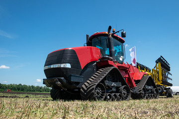 heavy red tractor at agricultural exhibition in motion