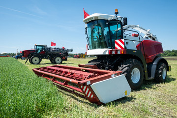 Fototapeta premium heavy powerful red harvester in the field during the demonstration