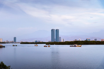 Ras Al Khaimah, United Arab Emirates - October 30, 2018: Ras Al Khaimah creek with boats pedaling on the water at dusk